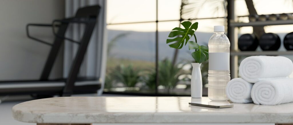 Copy space on white marble tabletop over blurred background of fitness room.